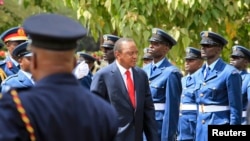 Kenyan President Uhuru Kenyatta inspects a guard of honor as he arrives at the Parliament Building to deliver his state of the nation address in Nairobi, March 27, 2014. 