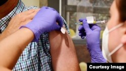 FILE - This undated file photo from Johnson & Johnson shows an experimental COVID-19 vaccine study undergoing late stage trials. The drug-maker announced Oct. 12 that it temporarily suspended the trials after an "unexplained illness." (Johnson & Johnson)