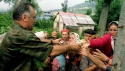 Prvostepeni ratni osuđenik Ratko Mladić deli hranu bošnjačkoj populaciji u Potočarima; 13. jul 1995.