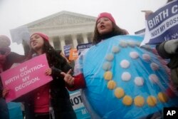 FILE - Margot Riphagen of New Orleans, La., wears a birth control pills costume during a protest in front of the U.S. Supreme Court in Washington, March 25, 2015.