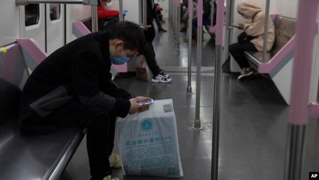 乘坐武汉地铁的乘客在看手机。(2020年4月1日)