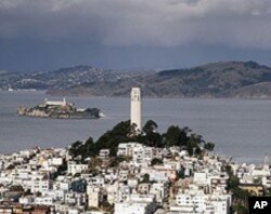 Alcatraz Island looms beyond Coit Tower in San Francisco in the 'Golden Gate,' which is not a bridge but the cold and rapid strait that the bridge crosses nearby.