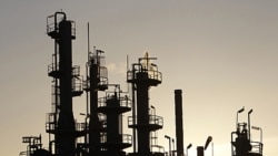 Towers and smokestacks are silhouetted at an oil refinery in Melbourne (2010 file photo)