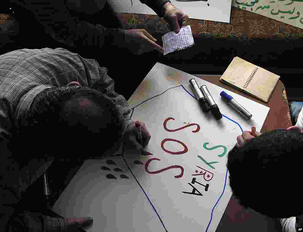 Syrian activists prepare signs for upcoming protests at a house in Damascus, April 3, 2012. (AP) 