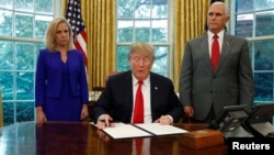 Rais Trump (C) na Makamu Rais Mike Pence na waziri Kirstjen Nielsen