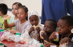 From left to right, students Vania Lopez Lopez, Genesis Yol, Kediga Ahmed, Mussa Ahmed, and Kiza Lulaca, eat lunch at Valencia Newcomer School Thursday, Oct. 17, 2019, in Phoenix. (AP Photo/Ross D. Franklin)