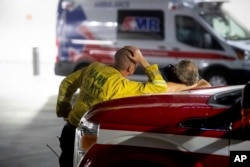 Marin County firefighters wait outside the Mercy Medical Center emergency room as an injured crew member receives treatment on July 26, 2018, in Redding, Calif.