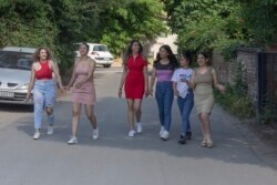 Dari kiri: Silvia Sinani, Dijana Ferhatovic, Zivka Ferhatovic, Elma Dalipi, Selma Dalipi dan Zlata Ristic, anggota band Pretty Loud, berjalan di sepanjang jalan di sekitar tempat tinggal mereka di Beograd, Serbia, Rabu, 16 Juni 2021. (AP)