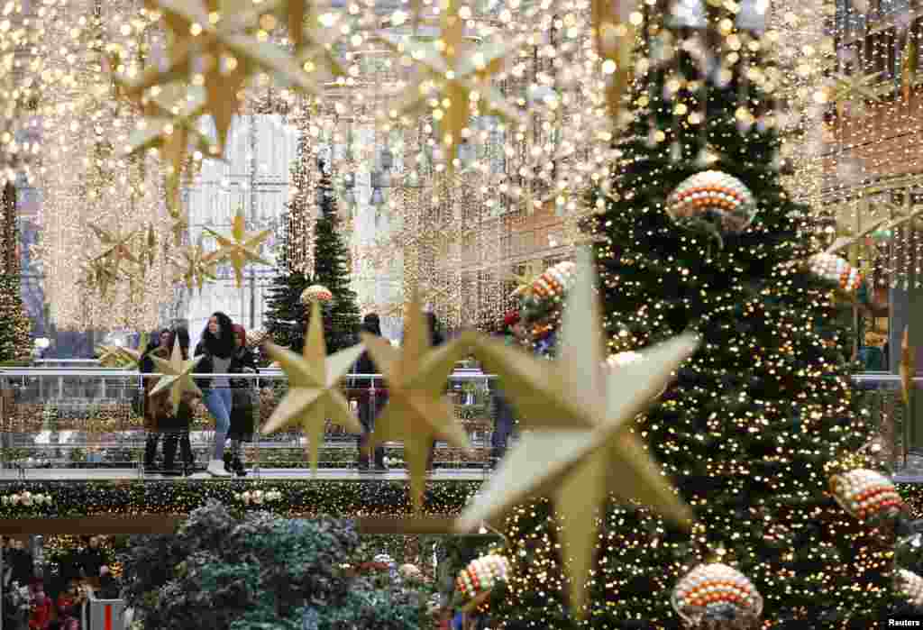 People walk in a shopping mall decorated with Christmas lights in Berlin, Germany.