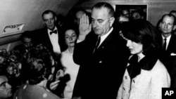 林登.约翰逊在肯尼迪被刺几个小时后宣誓就任总统，宣誓时肯尼迪夫人就在他身边