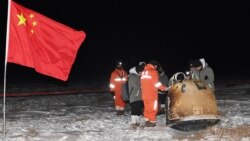 Researchers work around Chang'e-5 lunar return capsule carrying moon samples next to a Chinese national flag, after it landed in northern China's Inner Mongolia Autonomous Region, December 17, 2020. (China Daily via REUTERS)