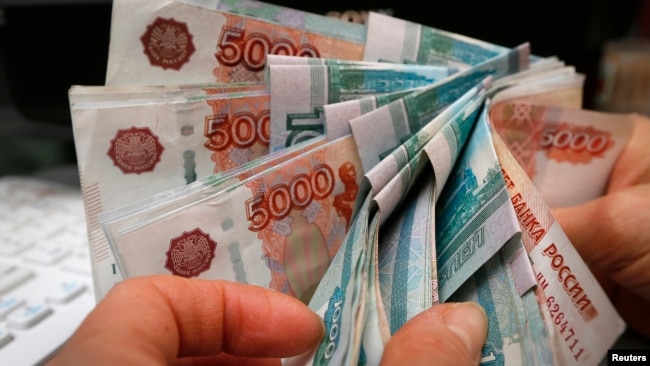 Một người đếm tiền rouble của Nga ở một cửa hàng (ảnh tư liệu, 2014). 