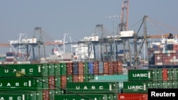 FILE - Cargo containers sit idle at the Port of Los Angeles as a back-log of over 30 container ships sit anchored outside the Port in Los Angeles, California, February 18, 2015.