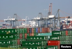 FILE - Cargo containers sit idle at the Port of Los Angeles as a back-log of over 30 container ships sit anchored outside the Port in Los Angeles, California, February 18, 2015.