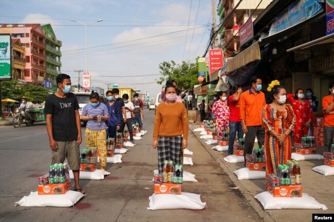 Workers receive food donations inside a 'red zone', which has stricter lockdown measures imposed due to the coronavirus disease (COVID-19) outbreak, in Phnom Penh, Cambodia, April 28, 2021. REUTERS/Cindy Liu