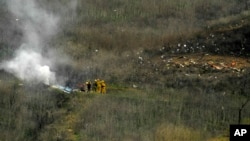 Para petugas pemadam kebakaran di lokasi kecelakaan helikopter yang menewaskan mantan pebasket NBA, Kobe Bryant, di Calabasas, California, 26 Januari 2020. (Foto: AP)