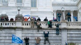 Supporters of President Donald Trump climb the west wall of the the U.S. Capitol on Wednesday, Jan. 6, 2021, in Washington. (AP Photo/Jose Luis Magana)