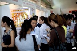FILE - Chinese job seekers visit a job fair held at the China International Exhibition Center in Beijing.