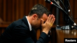Oscar Pistorius reacts in the dock ahead of his trial for the murder of girlfriend Reeva Steenkamp, North Gauteng High Court, Pretoria, March 5, 2014.