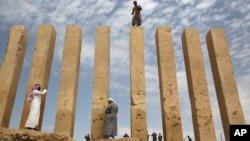 A Yemeni militiaman stands atop a limestone column at the Awwam Temple, Feb. 3, 2018. Experts fear the temple, as well as other historic and cultural wonders across Yemen beyond those acknowledged by international authorities, remain at risk as the country’s stalemated Saudi-led war against Shiite rebels rages on.