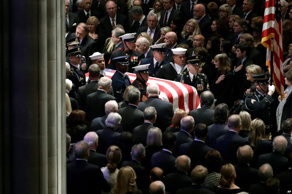 The flag-draped casket of former President George H.W. Bush is carried by a military honor guard during a State Funeral at the National Cathedral, Dec. 5, 2018, in Washington.