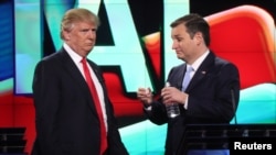 Republican U.S. presidential candidate Donald Trump (L) talks with rival Ted Cruz during a commercial break in the midst of the Republican U.S. presidential candidates debate sponsored by CNN at the University of Miami in Miami, Florida, March 10, 2016. 
