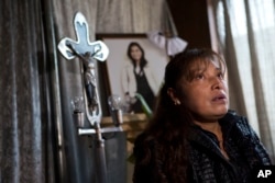 Juana Pedraza sits by a shrine to her slain daughter Jessica Sevilla Pedraza, a 29-year-old doctor and mother, during an interview inside her family's home in Villa Cuauhtemoc, Mexico state, Aug. 18, 2017.