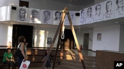 People view an exhibition by leftist Turkish victims of the Sept. 12, 1980 military takeover that shows a replica of the gallows used to hang suspects, torture devices as well as letters, newspapers, clothes and photographs of comrades who died, went mi