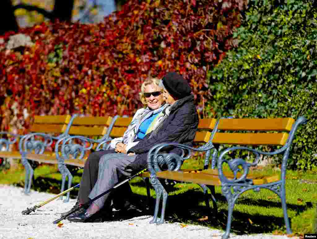 &nbsp;آسٹریا کے ایک پارک میں موسم خزاں کی دھوپ سے دو لوگ لطف اندوز ہوتے ہوئے۔