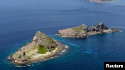 FILE - Part of a group of disputed islands, Minamikojima (bottom) and Kitakojima, known as Senkaku in Japan and Diaoyu in China, seen in the East China Sea, in this photo taken by Kyodo.