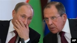 FILE - Russian President Vladimir Putin, left, listens to Foreign Minister Sergey Lavrov at a Kremlin ceremony in Moscow, April 15, 2013.