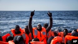 Des migrants clandestins secourus disent des prières à bord d’un canot gonflable près de la côte libyenne, 12 janvier 2017.