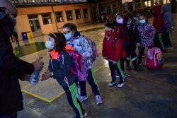 Antrean siswa mengenakan masker, sebelum memasuki sekolah Luis Amigo setelah liburan Natal, di Pamplona, Spanyol utara, 10 Januari 2022.