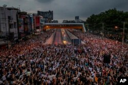 Pro-democracy activists throw three-finger salutes during a rally at the intersection of Kaset, suburbs of Bangkok, Thailand, Monday, October 19, 2020. Thai authorities worked Monday to stop a growing wave of protests demanding that the prime minister resolve