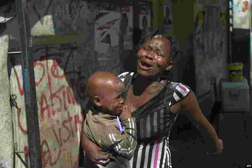 Haitidə prezidentliyə namizəd Maryse Narcissenin tərəfdarları ilə polis arasındakı toqquşma zəminində qadın gözyaşardıcı qaza reaksiya verir. Port-au-Prince, Haiti.