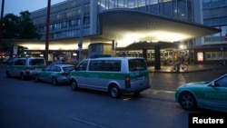 Des véhicules de la police allemande sont garés devant un centre commercial à Munich, Allemagne, le 22 juillet 2016.