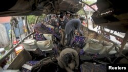 Police and rescue personnel search a bus damaged in a bomb blast in Peshawar, Pakistan March 16, 2016.
