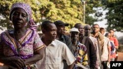 Voters queue outside a polling station in Bangui on Dec. 13, 2015 to vote for the constitutional referendum, seen as a test run for presidential and parliamentary polls scheduled two weeks later aimed at ending two years of sectarian strife in the Central