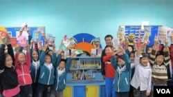 A class poses in front of their library with philanthropist Nguyen Quang, An Bai primary school, Thai Binh province, Vietnam, November 24, 2012. (M. Brown/VOA)