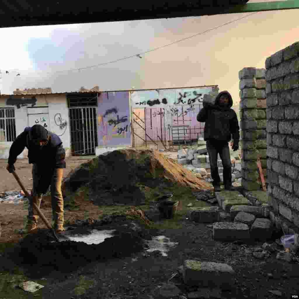 Warga membangun kembali daerah yang dirusak selama kekuasaan Negara Islam (ISIS) di kota Qayyarah, sebelah selatan Mosul, Desember 2016. (VOA/Kawa Omar)