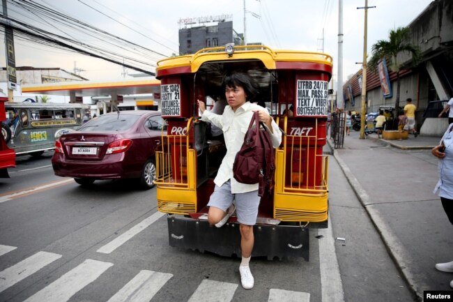 Oliver Emocling, 23, who works for a magazine, gets off a jeepney near his office in Makati City, Philippines, Nov. 29, 2018.