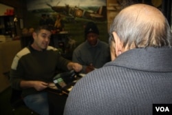 Alan Coleman speaks with a war veteran who has brought him medals and badges to evaluate. (D. Taylor/VOA)