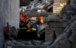 Petugas bekerja di bawah puing-puing bangunan yang rusak setelah gempa di Thumane, Albania, 27 November 2019. (Foto: REUTERS/Florion Goga)