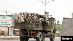 Les soldats patrouillent à bord d’un camion sur une route à Maiduguri dans l'Etat de Borno, au Nigeria, 14 mai 2015