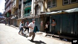 A Nepalese man runs to safety after a second earthquake hit Nepal in Kathmandu, May 12, 2015. 