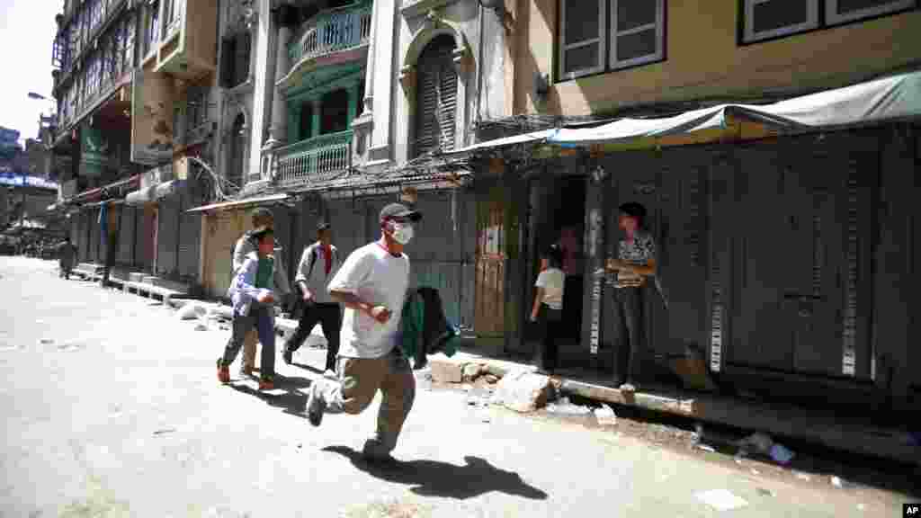 Des Népalais accourent se mettre à l&#39;abri après un deuxième tremblement de terre qui a frappé Katmandou, au Népal, mardi 12 mai 2015.