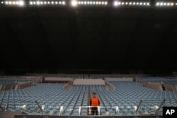 FILE - In this Sept. 30, 2014, photo, a steward stands amidst empty seats in a stadium devoid of fans during the Group E Champions League match between CSKA Moscow and Bayern Munich at Arena Khimki stadium in Moscow. CSKA had to play 3 matches behind closed doors.