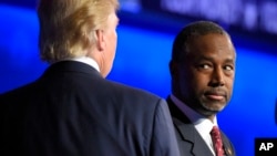 FILE - Ben Carson watches as his main rival, real estate mogul Donald Trump, takes the stage during a Republican presidential debate at the University of Colorado, Oct. 28, 2015.