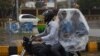 کراچی میں موٹر سائیکل سوار افراد نے بارش سے بچاؤ کے لیے خود کو پلاسٹک بیگ میں چھپایا ہوا ہے۔
