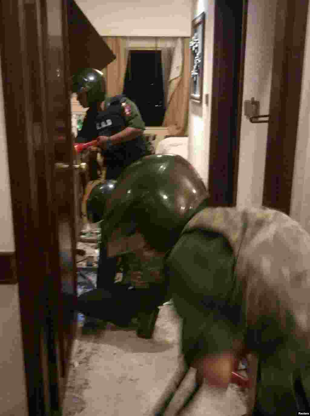Soldiers inspect a room where an explosion occurred at Traders Hotel in central Rangoon, Burma, Oct. 15, 2013. 